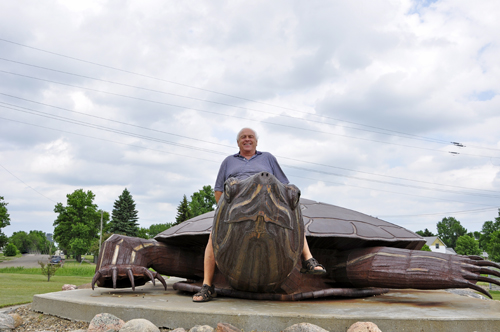 Lee Duquette rides Rusty the giant turtle in ND